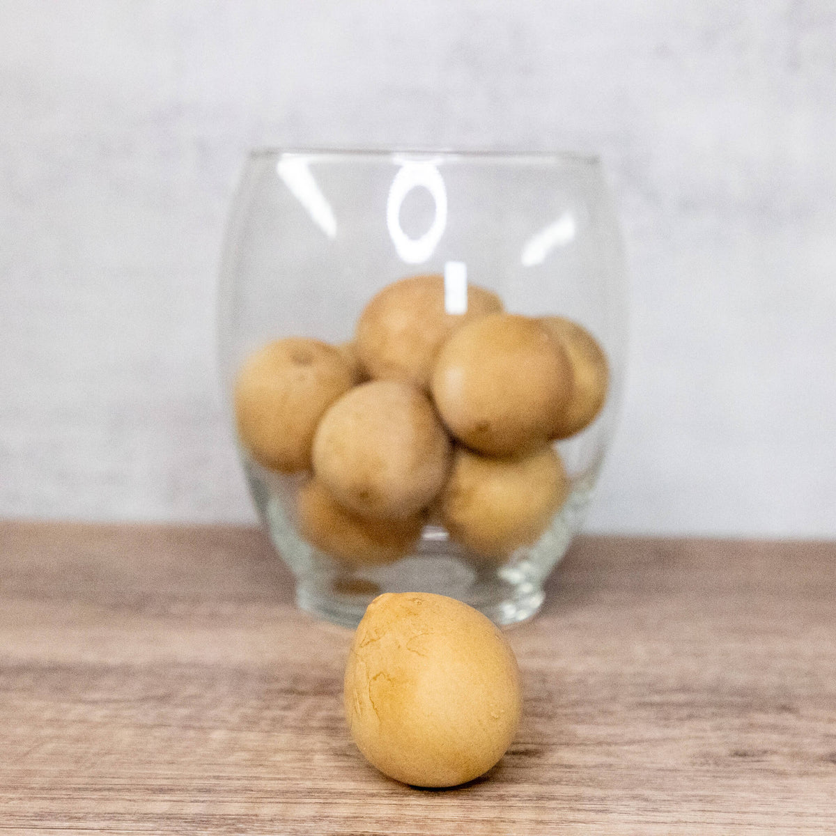 1 inch dried egg gourd balls in a pack of 10 while styled in a glass flute at Meadowbrooke Gourds.