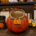 Decorative gourd with a pine needle woven edge, wood pumpkin adornment in a rich rusty color.