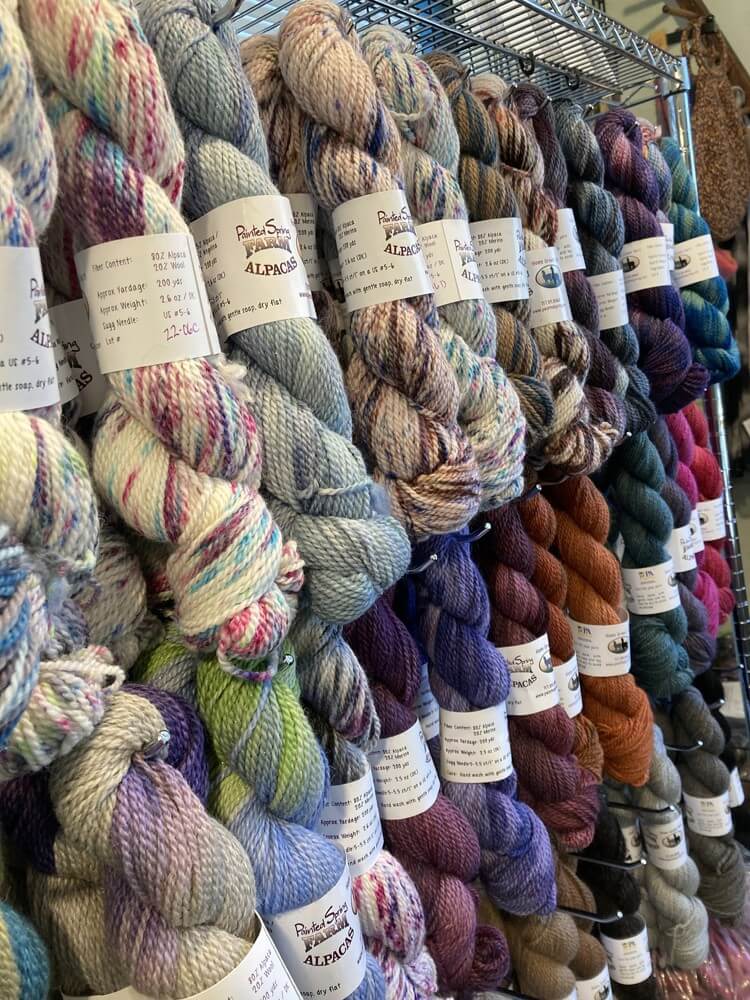 Multi colored yarns hanging on a metal rack